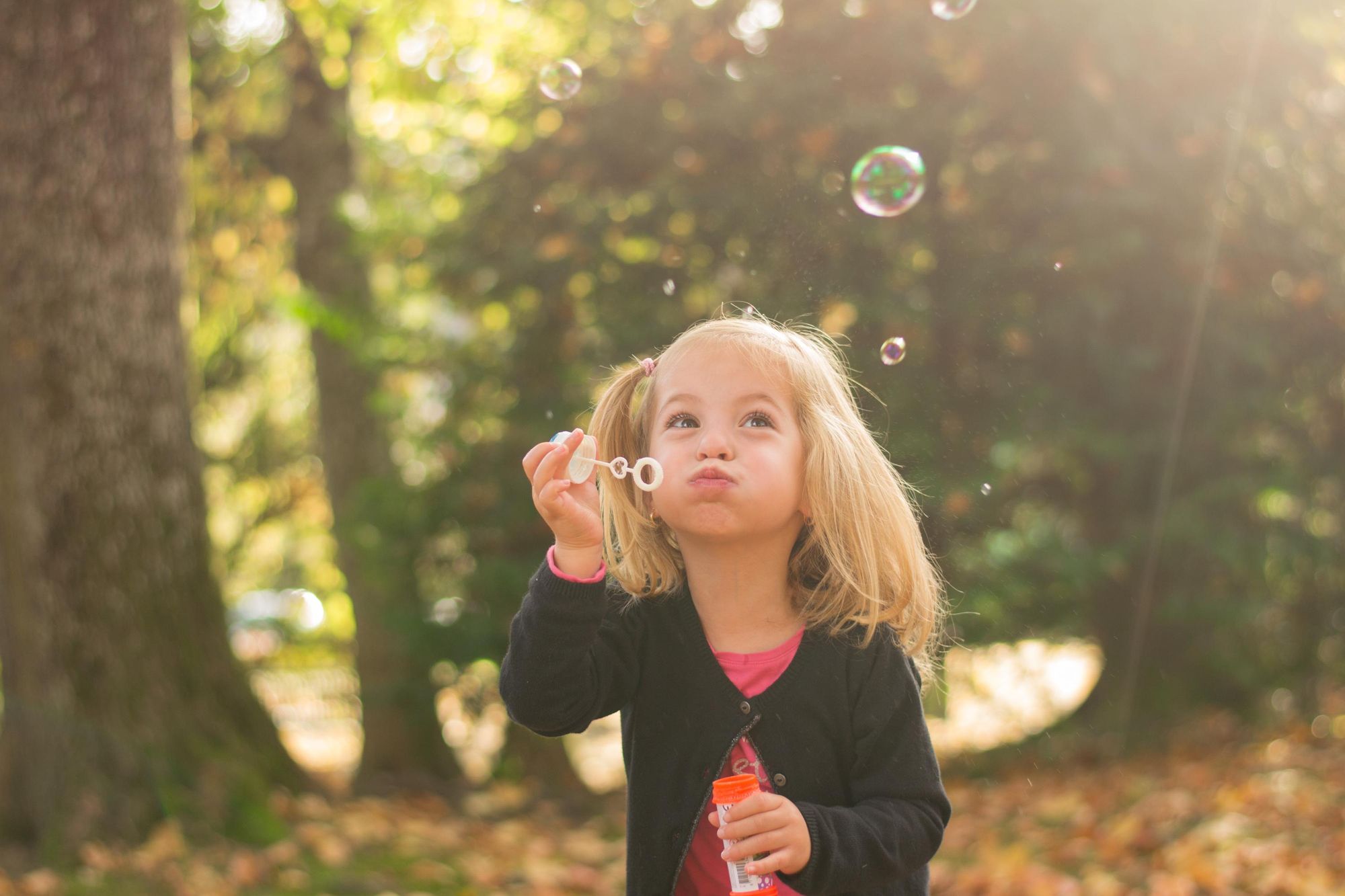 photo d'une petite fille qui fait des bulles de savon lors d'une session famille dans le grand est