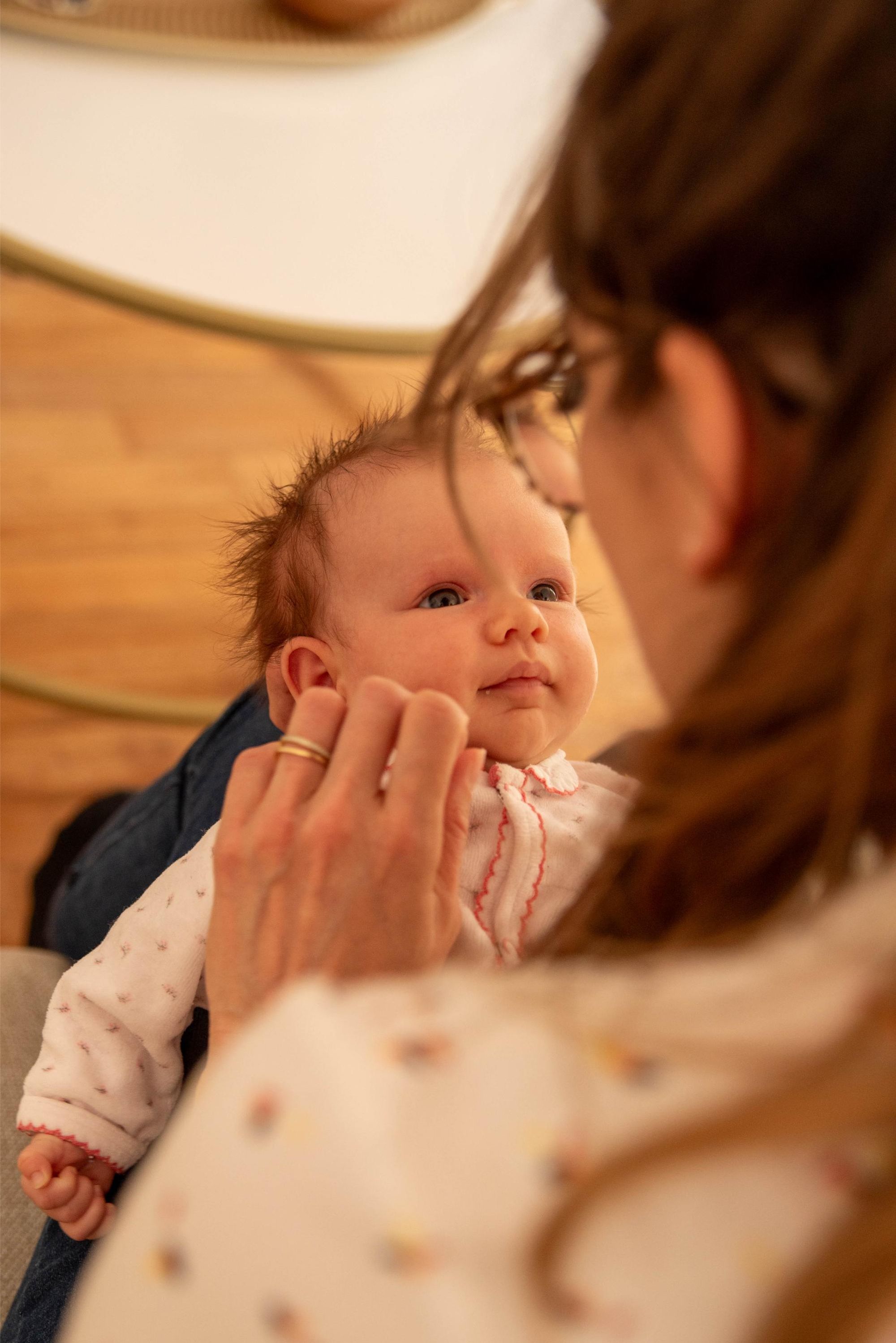 photo à domicile d'un nouveau-né qui regarde sa maman avec amour