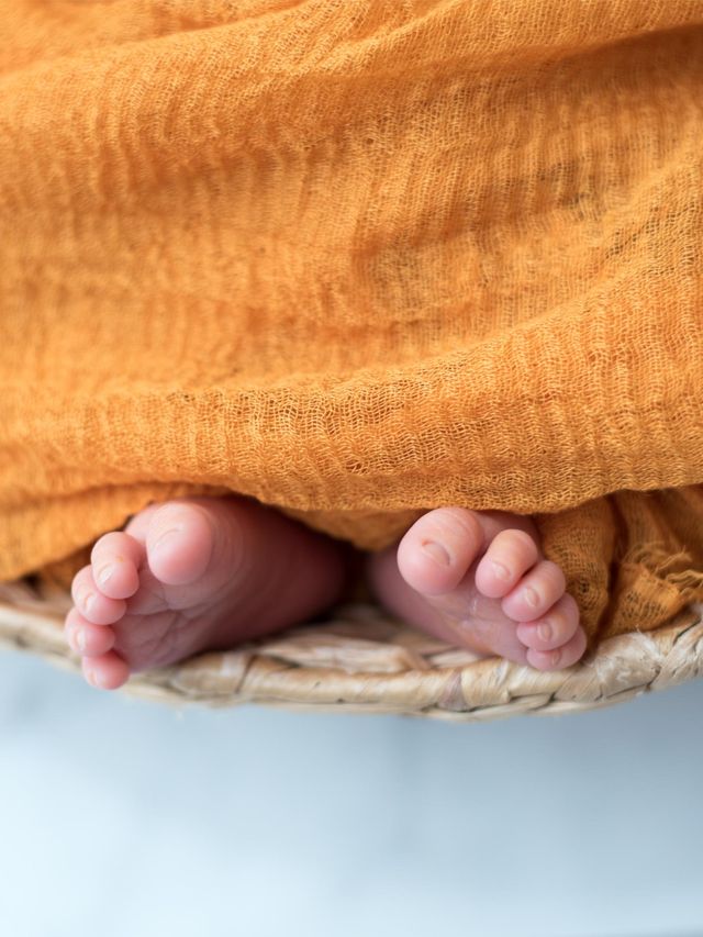Photo de naissance, pieds d'un bébé dans un panier avec un flou artistique