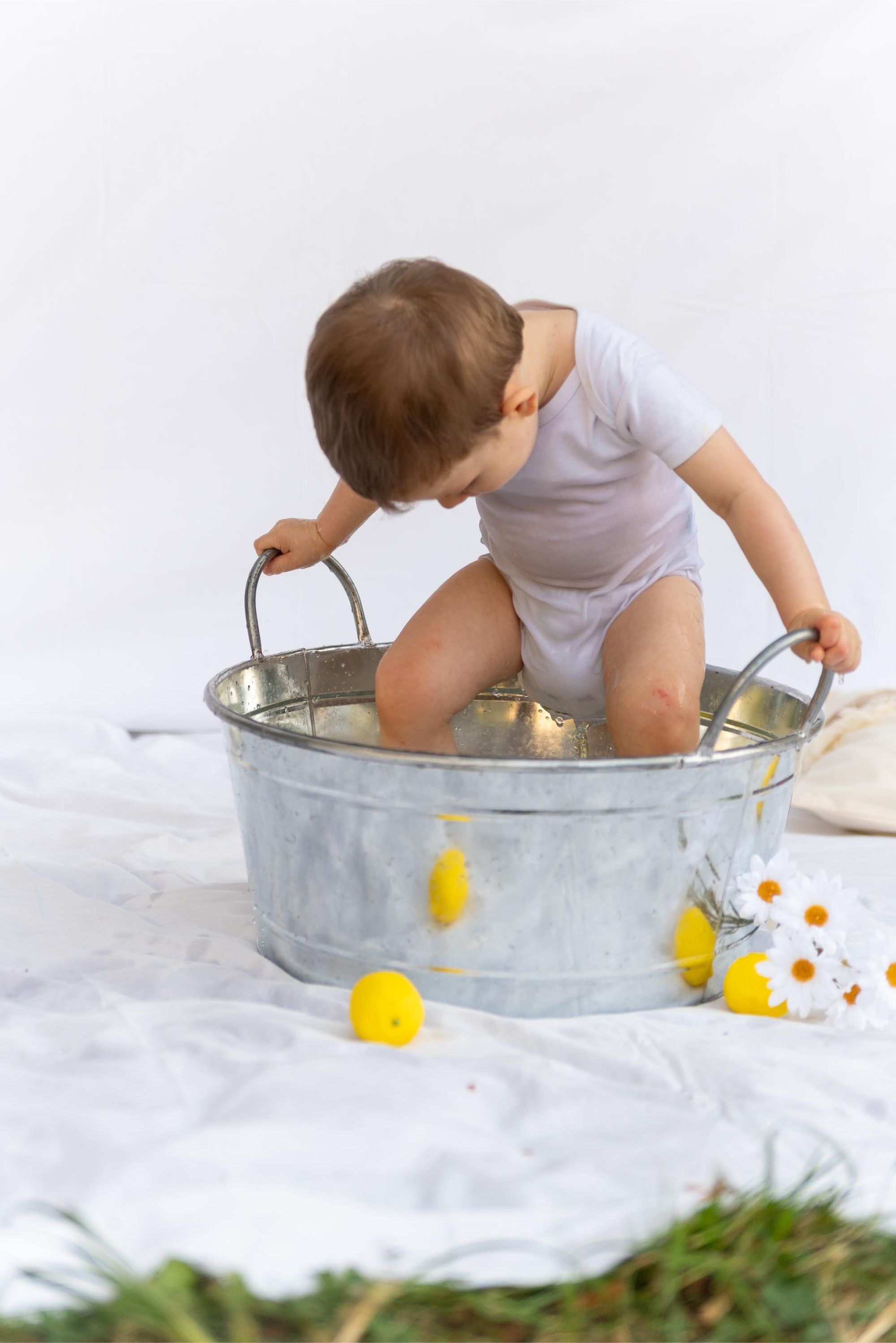 photo d'enfant dans une bassine en extérieur lors d'une mini session thème citron  à Besançon 