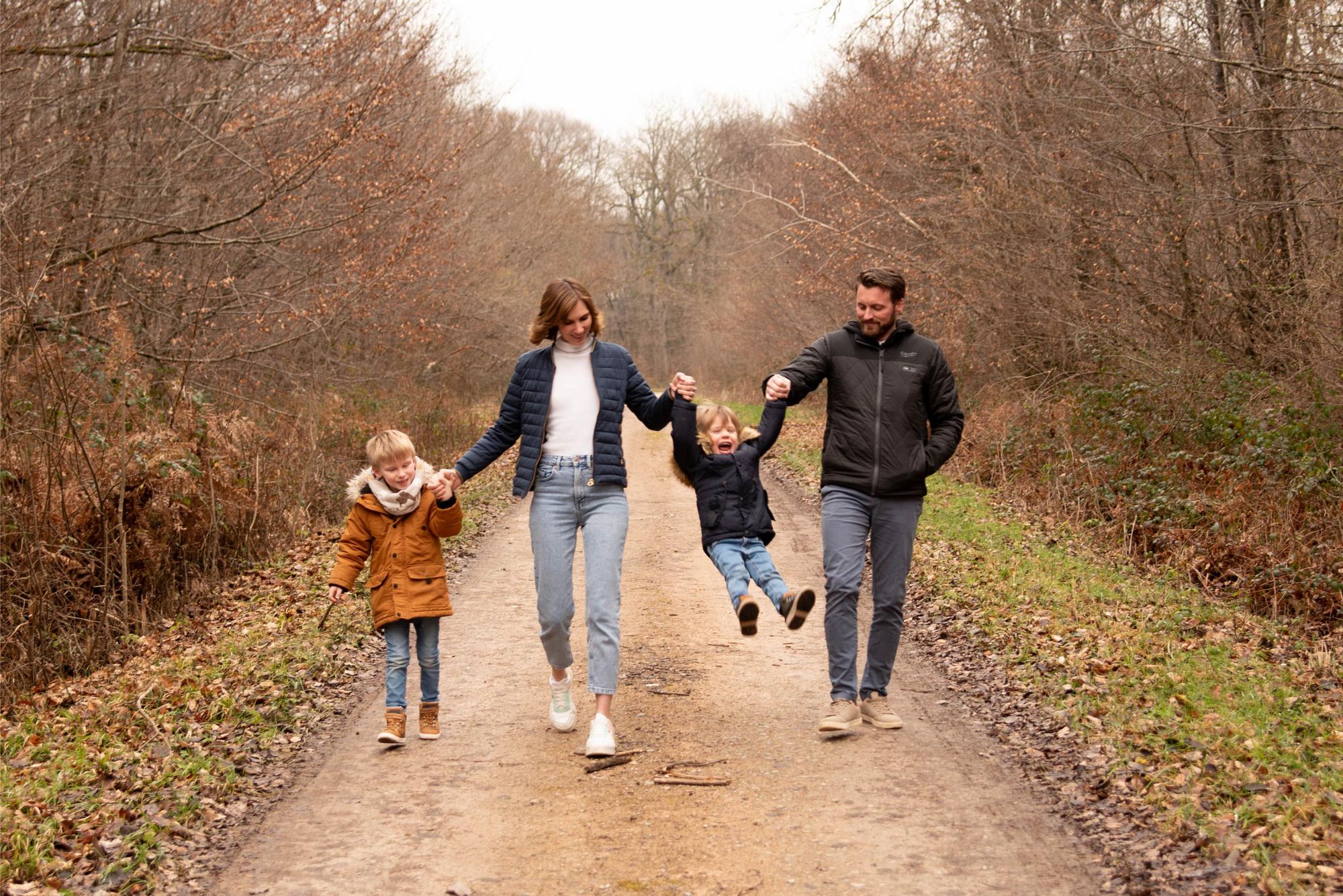 photo d'une famille lors d'une séance photo qui joue avec leurs enfants dans une foret proche de Franois