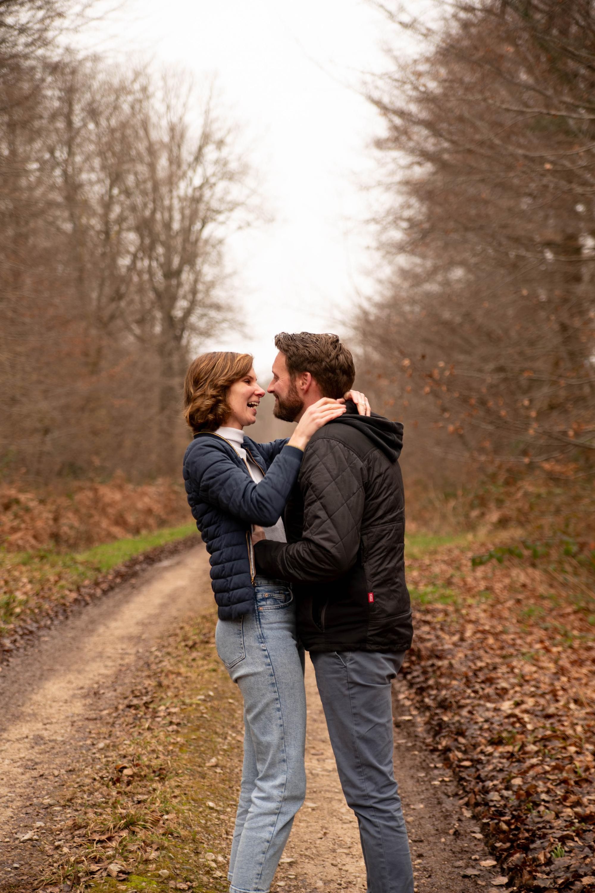 photo d'un couple qui rigole près à s'embrasser dans une foret proche de Besançon