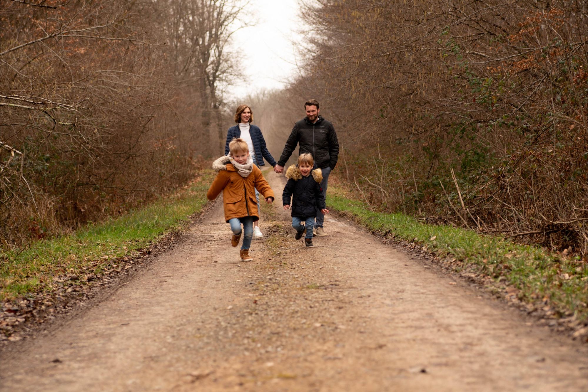 photo d'une famille heureuse lors d'une séance lifestyle en foret prise par une photographe professionnelle à Besançon