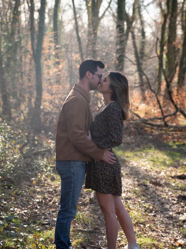 photo d'un couple qui s'embrasse dans la foret sous une lumière dorée. Ils ne posent pas et vivent le moment en toute simplicité et semblent très heureux lors de cette séance photo couple.