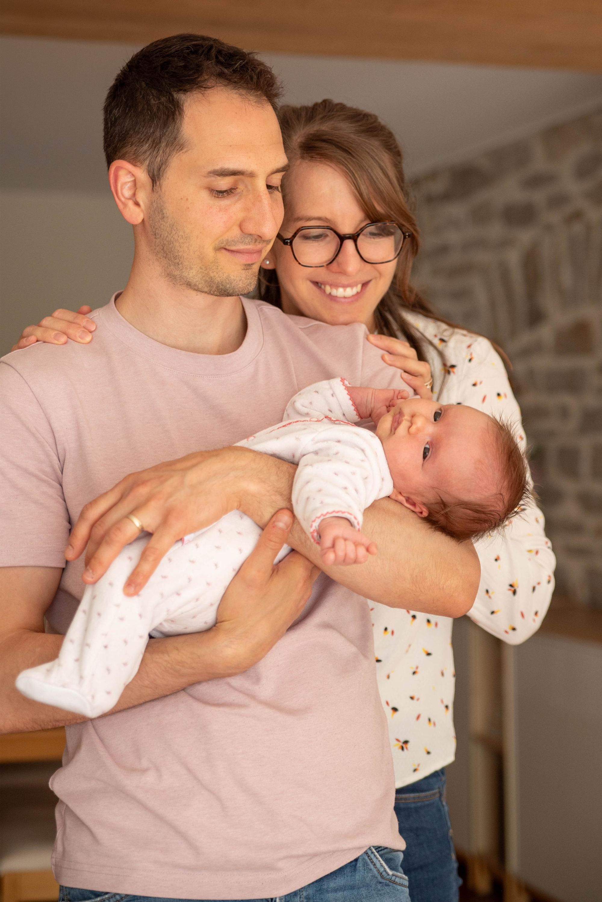 photo d'une petite fille dans les bras de son papa  lors d'une session naissance à Besançon