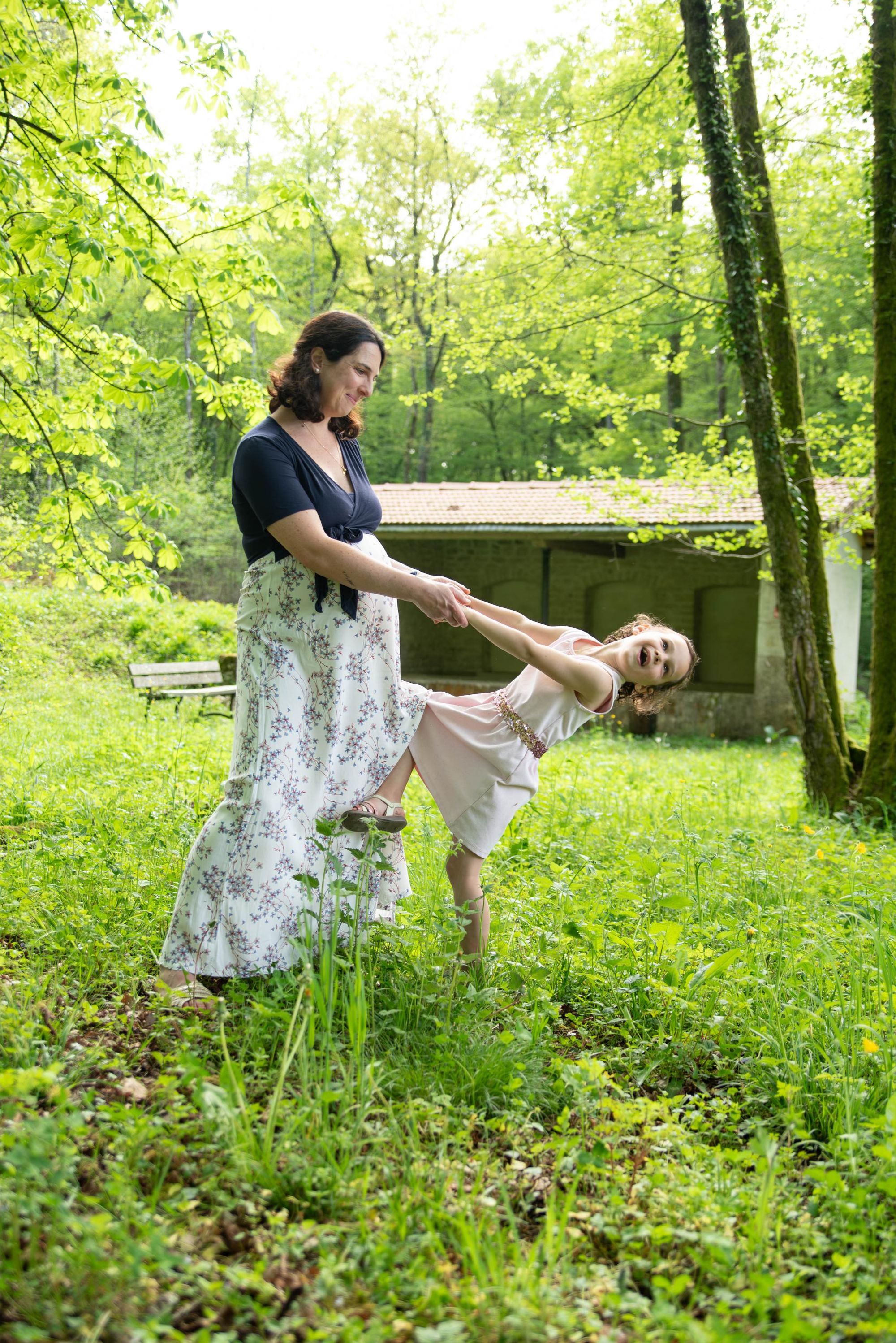 photo d'une maman et sa fille qui jouent lors d'une séance grossesse en foret à Torpes