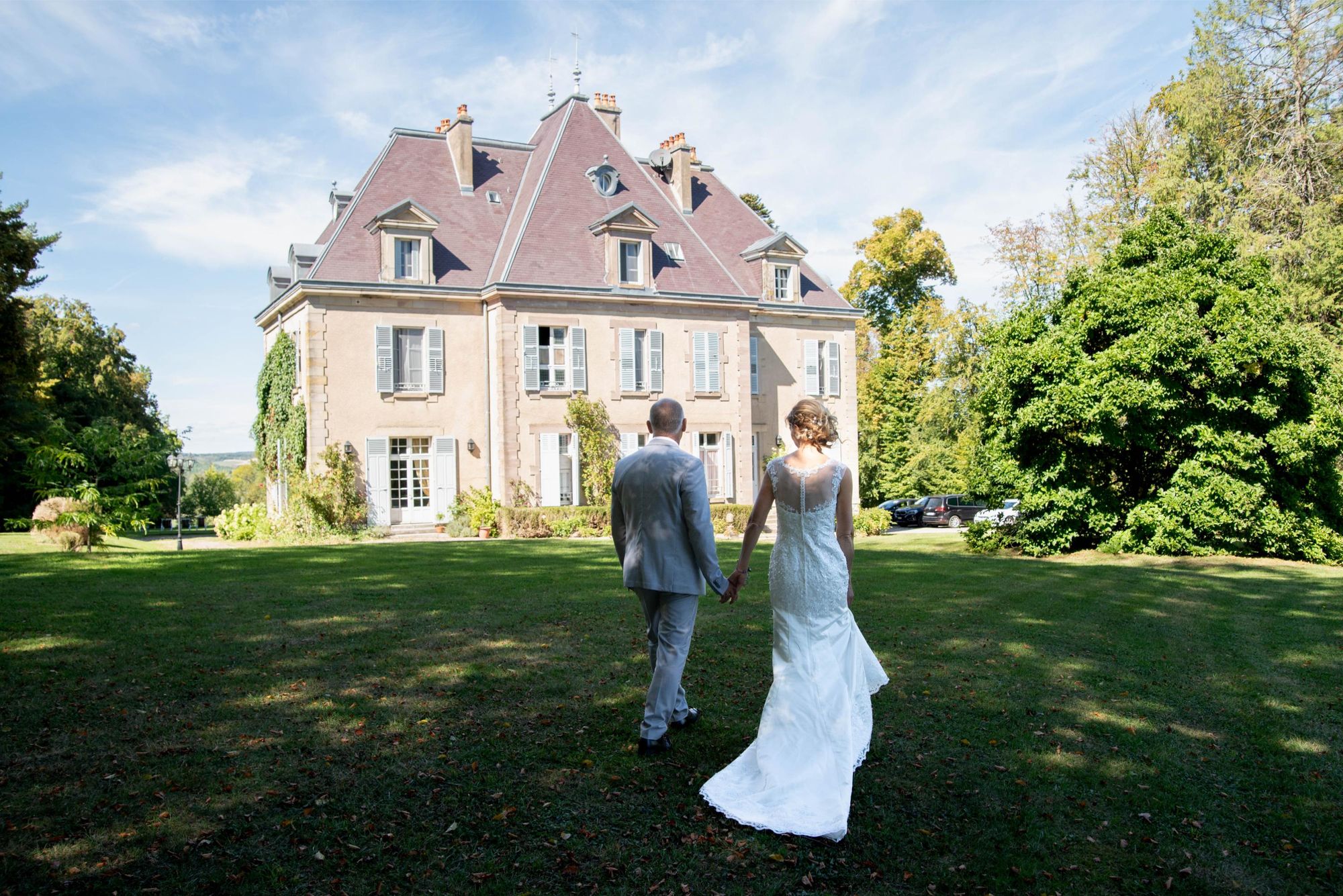 photo de marié de dos, marchant main dans la main, chateau en arrière plan proche de vesoul