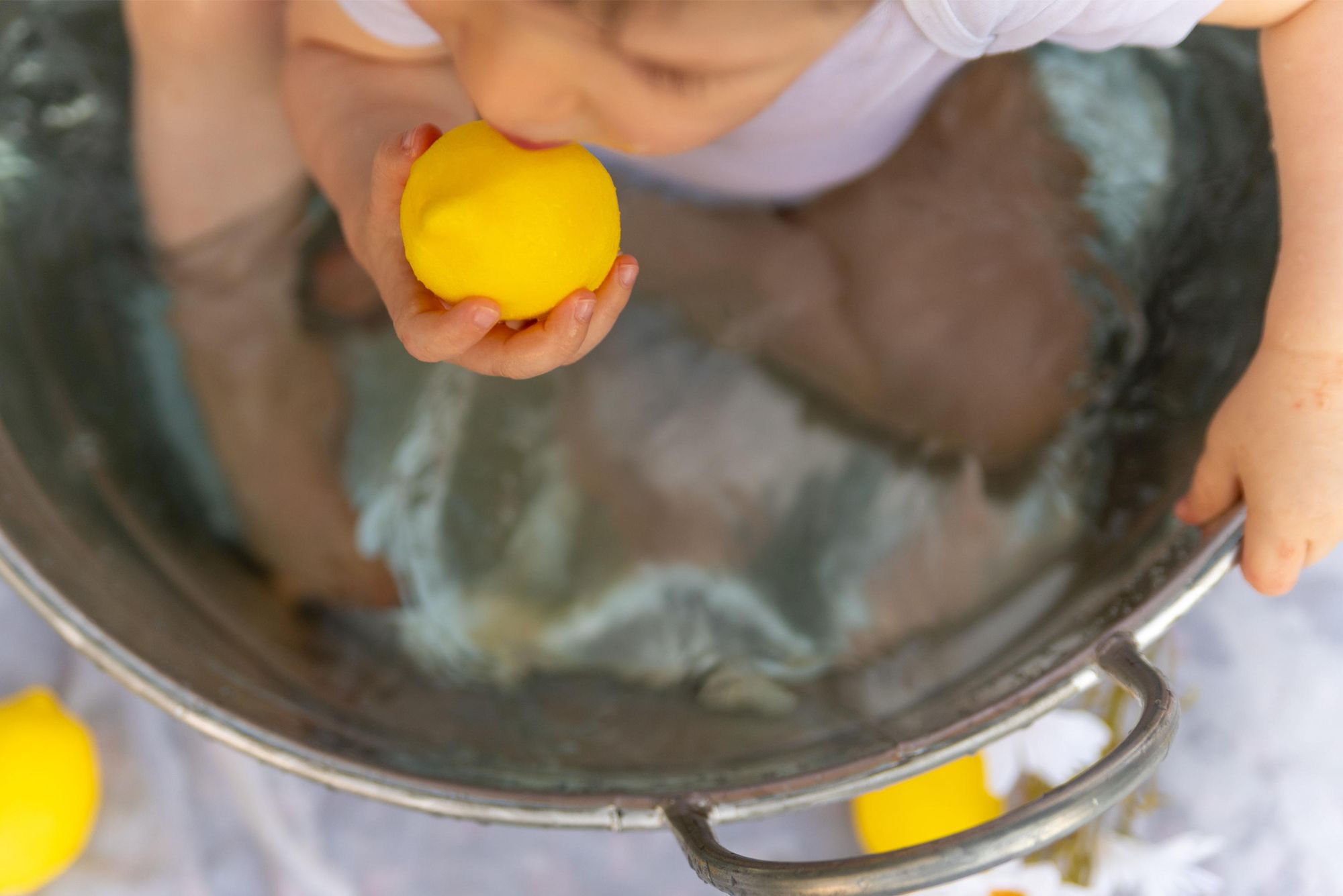 détail d'enfant avec des citrons à coté de Besançon en extérieur lors d'une mini session photo en extérieur 