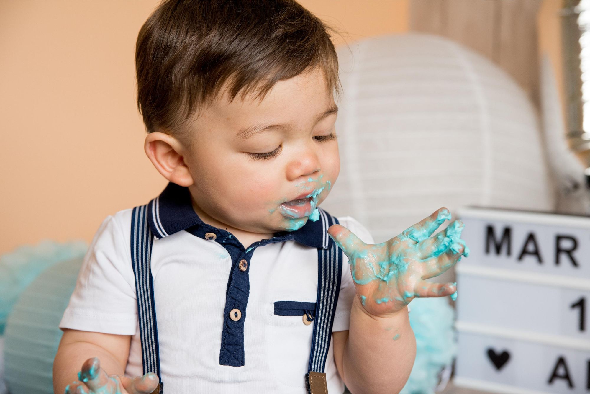 photo d'un petit garçon lors d'un smash the cake à domicile, pour un anniversaire  dans le grand est 