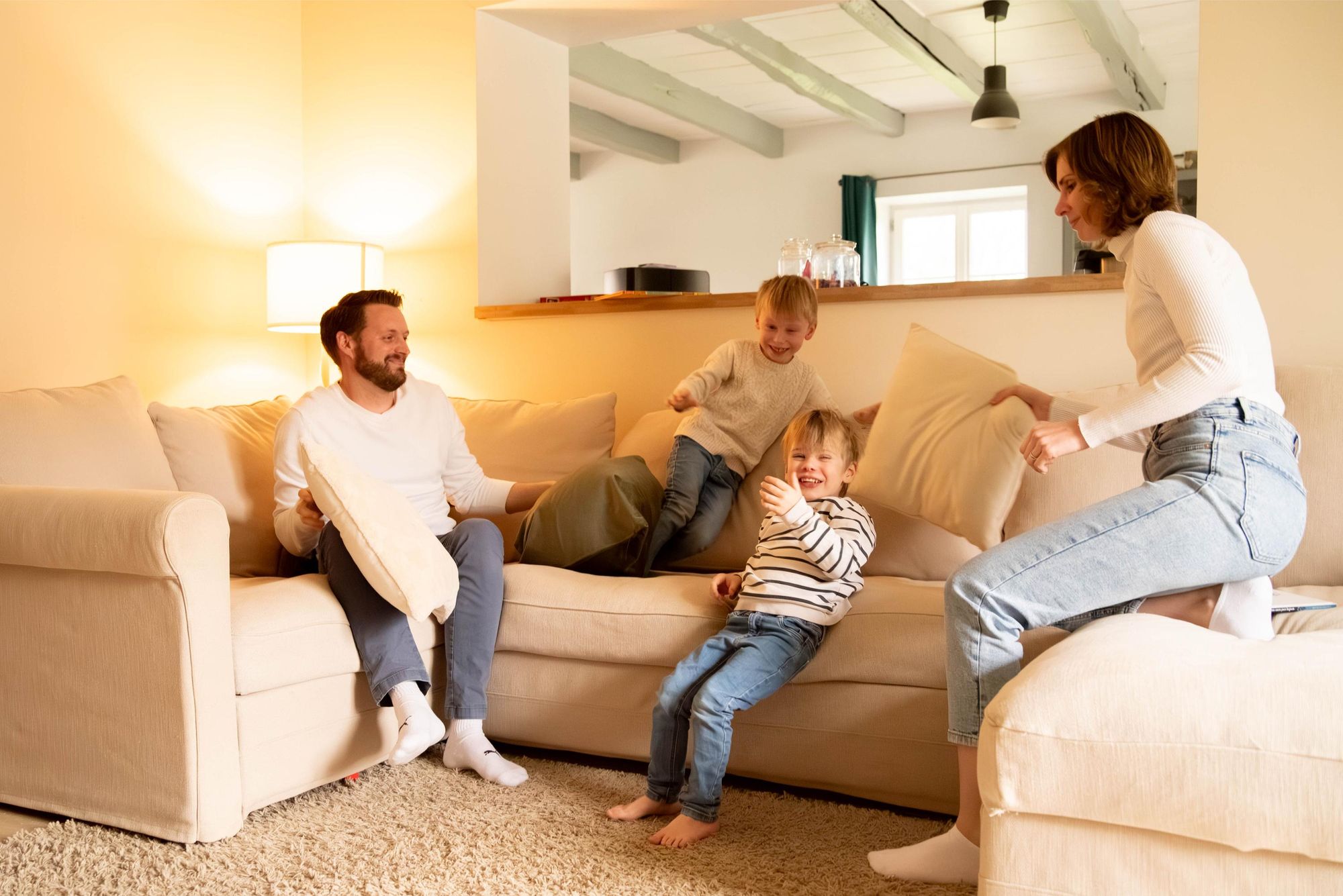 photo d'une bataille de coussin lors d'une séance photo famille lifestyle à Besançon