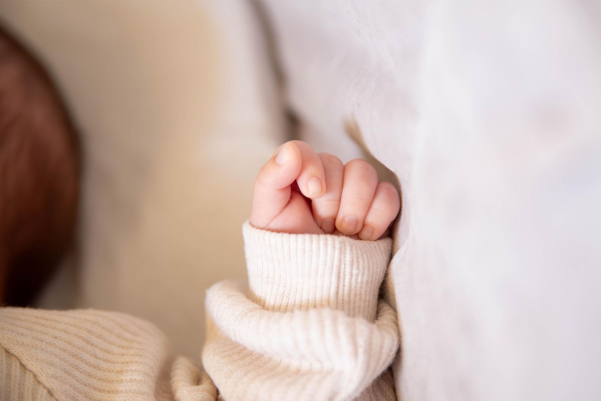 photo de détail d'une petite main de bébé lors d'une séance photo à domicile à Besançon