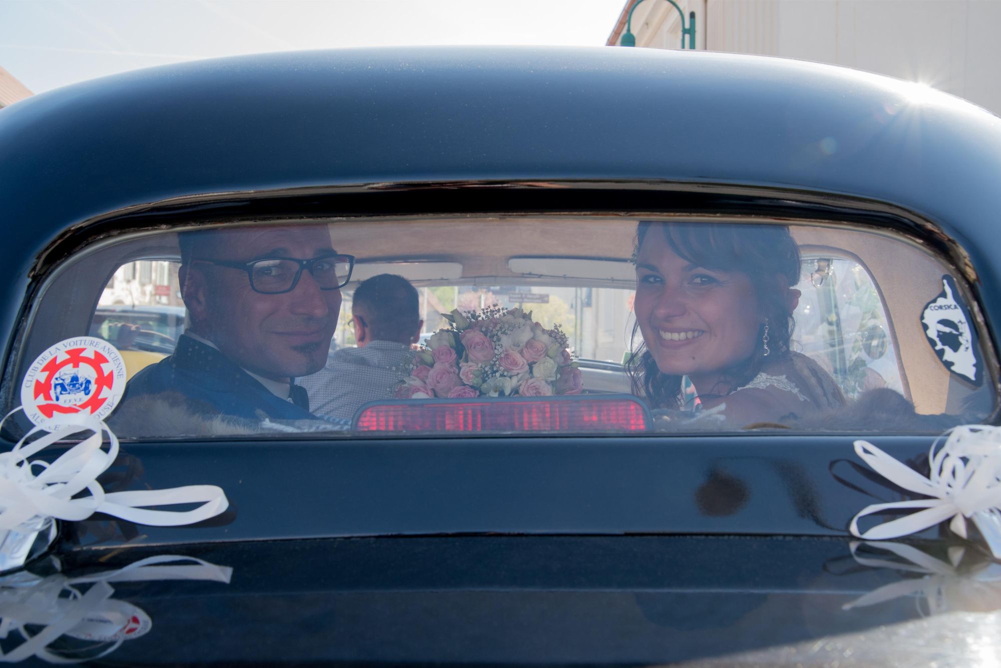 photo de regards des mariés au départ de la mairie à bord d'une voiture ancienne, mariage chic et intemporel, dans le grand est