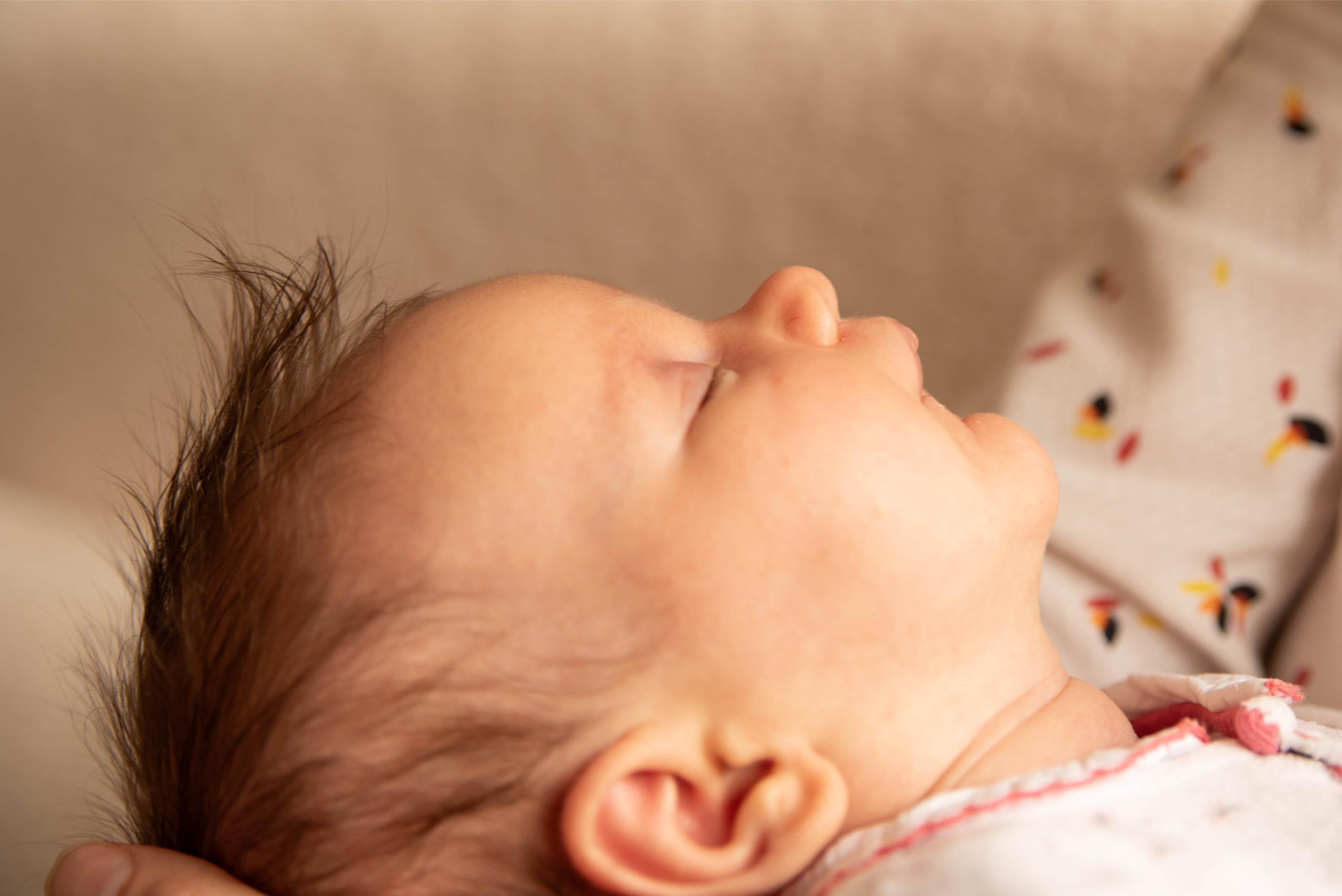 photo de détail de la courbe du visage d'un nouveau né lors d'une session naissance réalisée à domicile