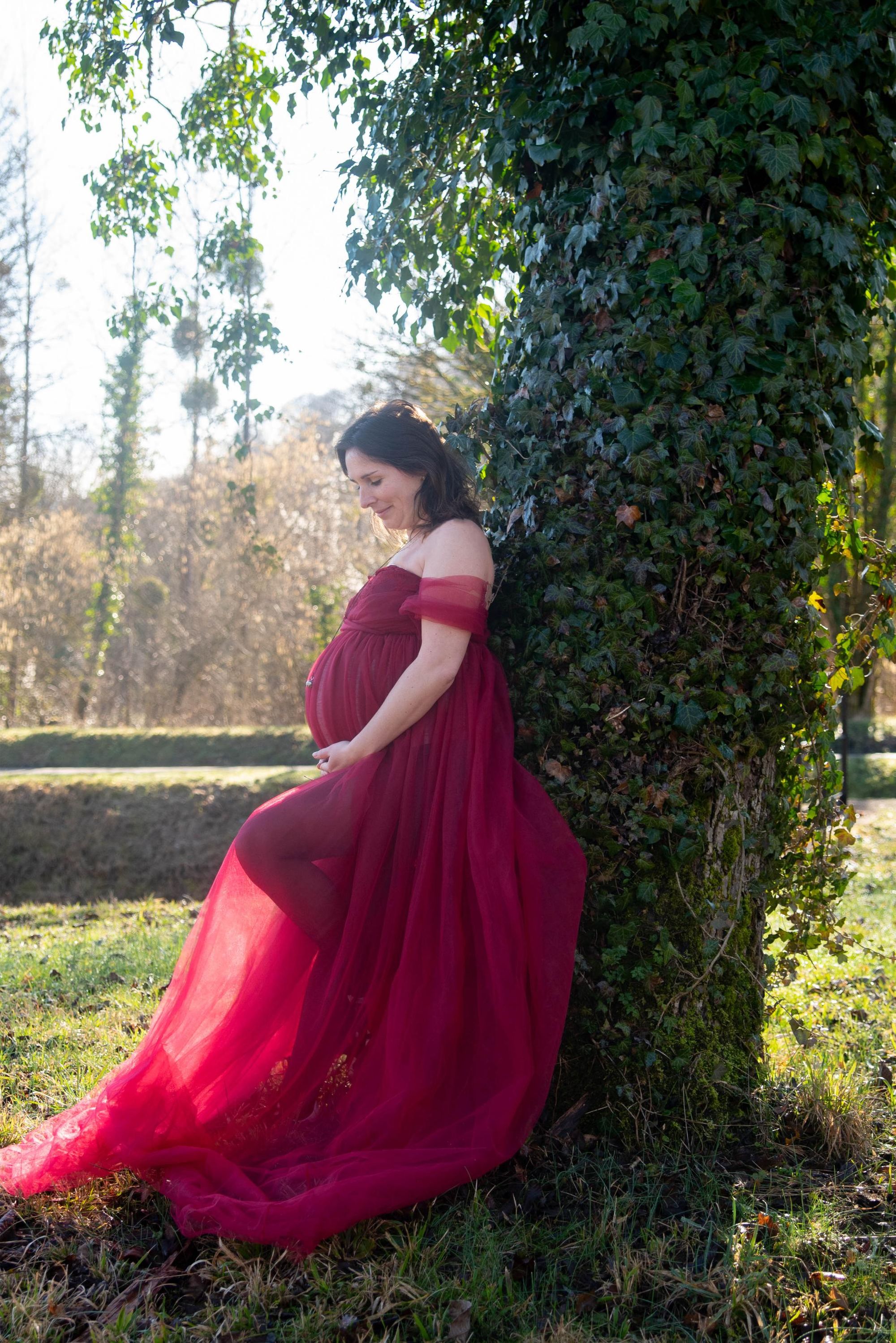 photo d'une future maman qui regarde son ventre avec émotion lors d'une session grossesse à Besançon