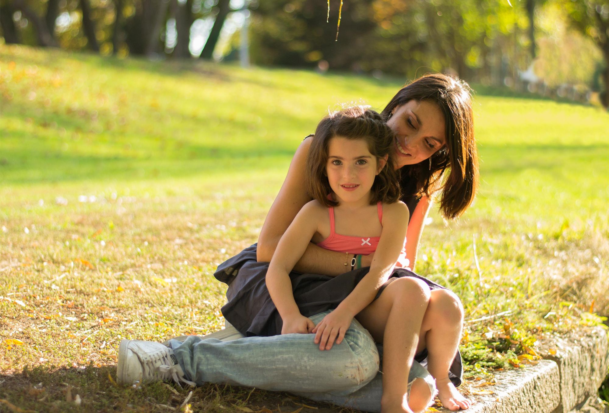 photo d'une une maman et sa fille assise dans un parc lors d'une session famille en été dans le grand est