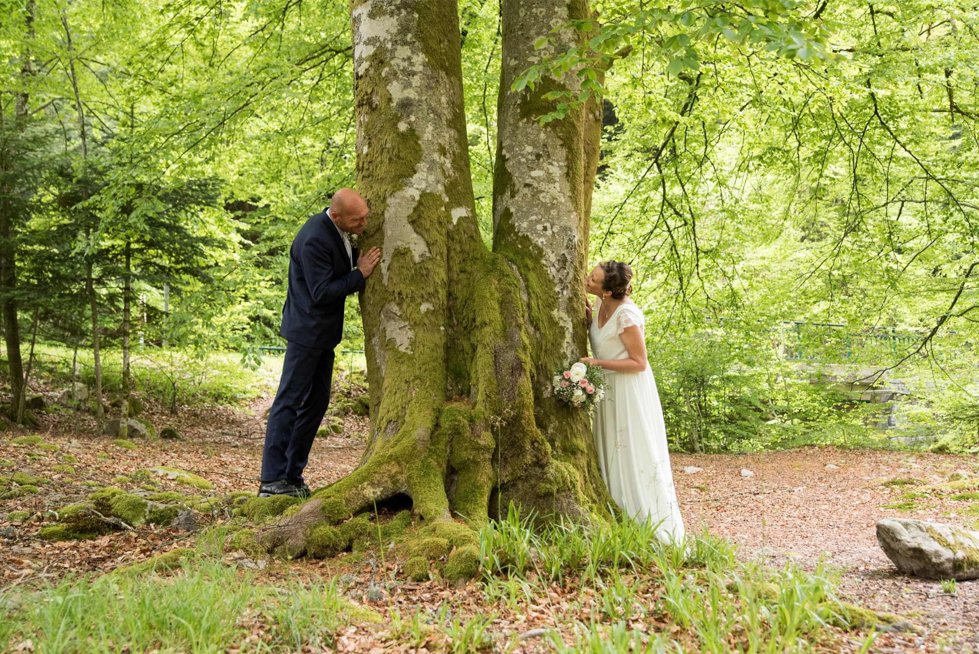 mariés qui jouent lors de leur séance couple, dans une foret dans le grand est. mariage bohème chic