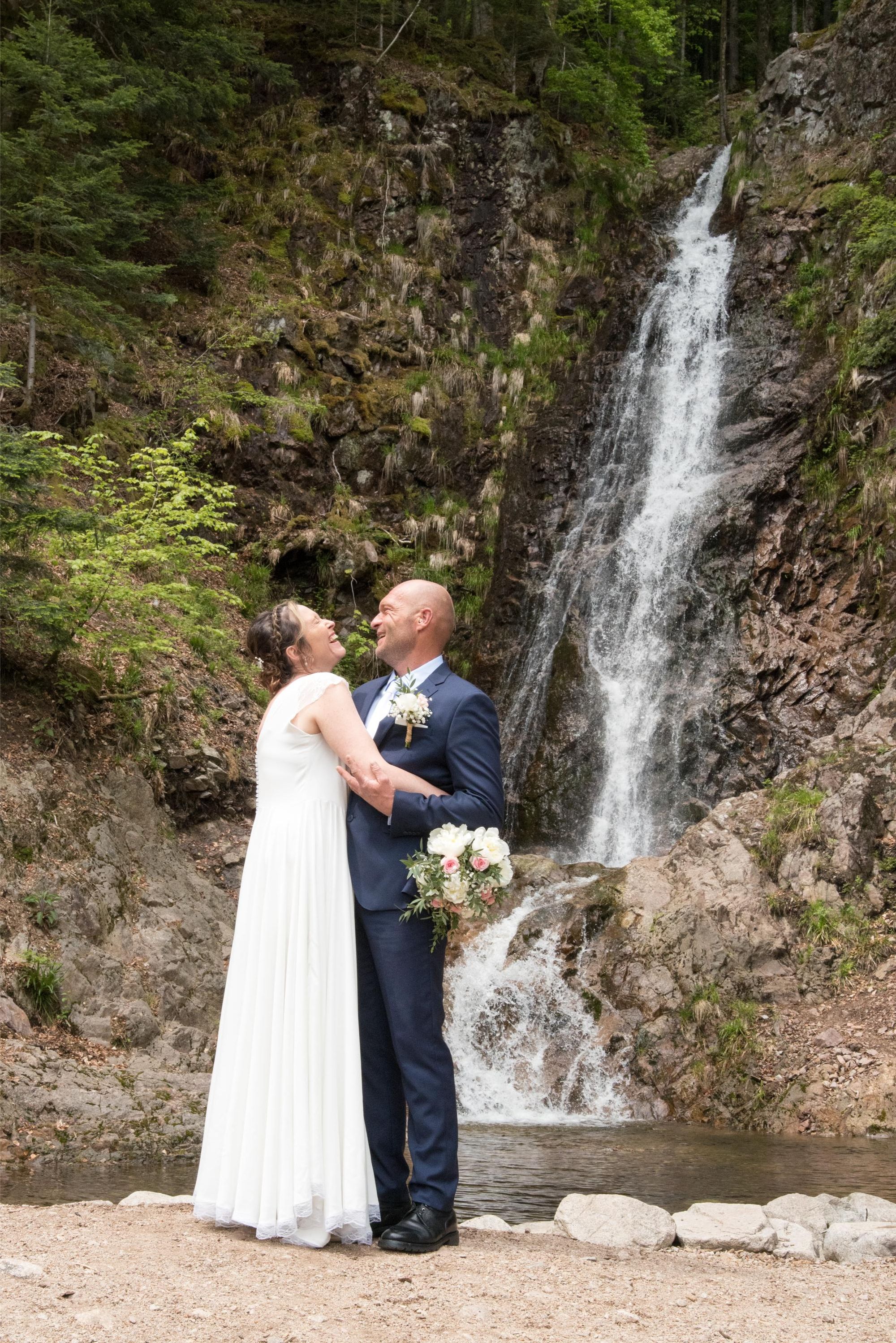 photo de mariés en plein fou rire devant une cascade, mariage bohème chic dans le grand est