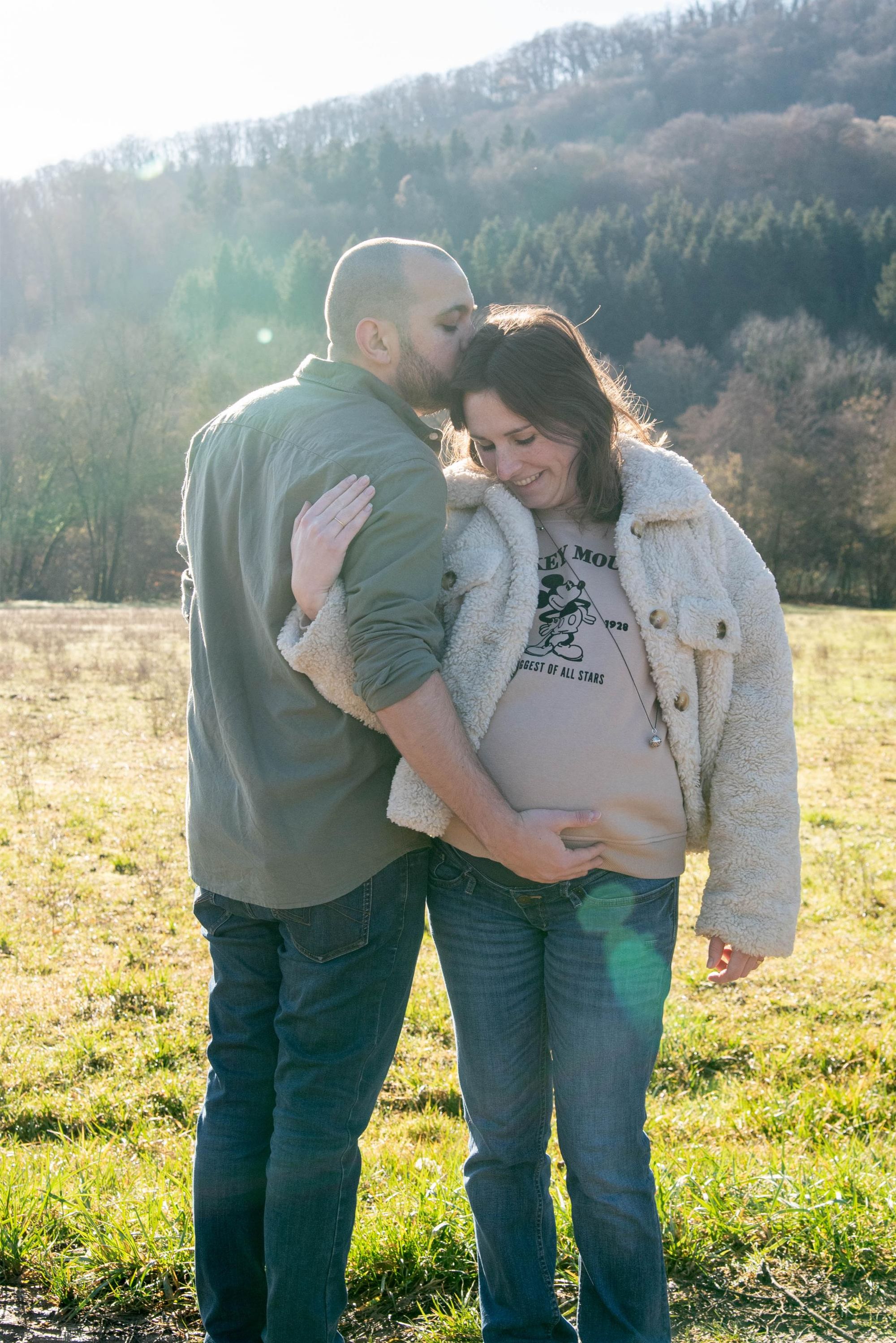 photo d'un couple amoureux lors d'une session grossesse en extérieur, au bord du Doubs près de Besançon