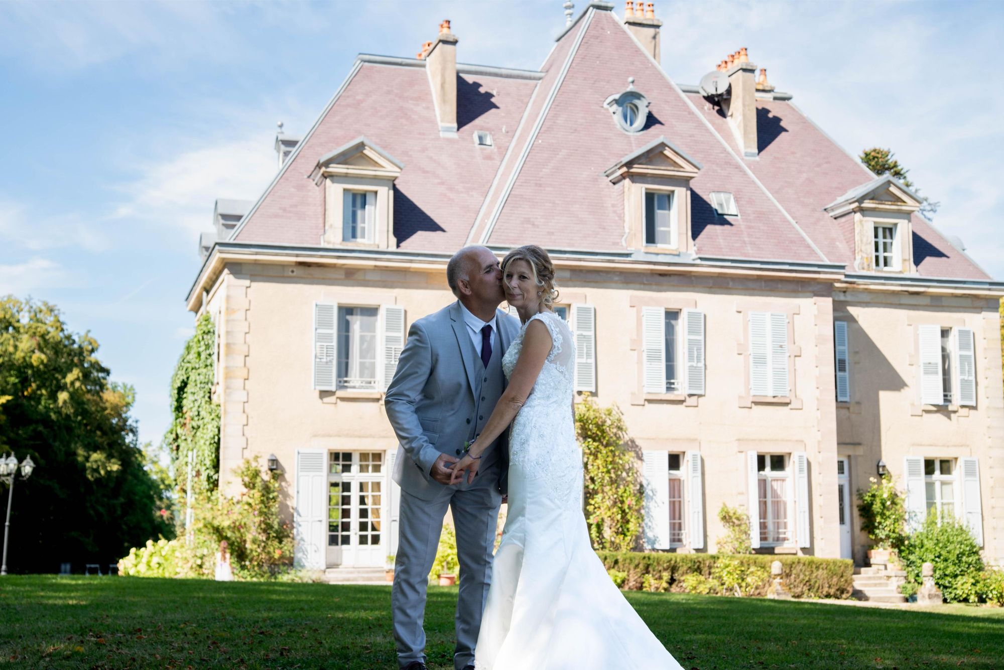 mariés qui s'embrassent devant un chateau proche de vesoul, mariage chic et intemporel