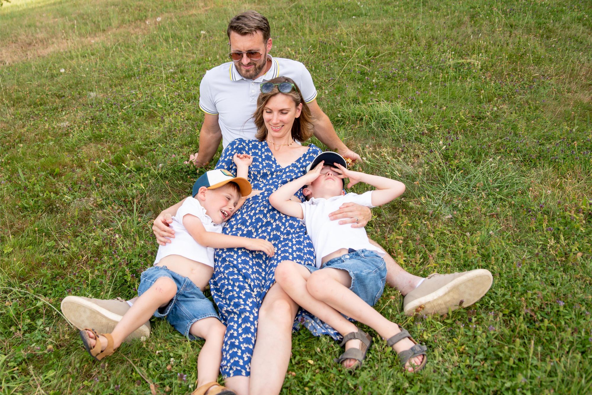 famille qui joue dans l'herbe pendant une séance photo lifestyle à Marnay dans le doubs