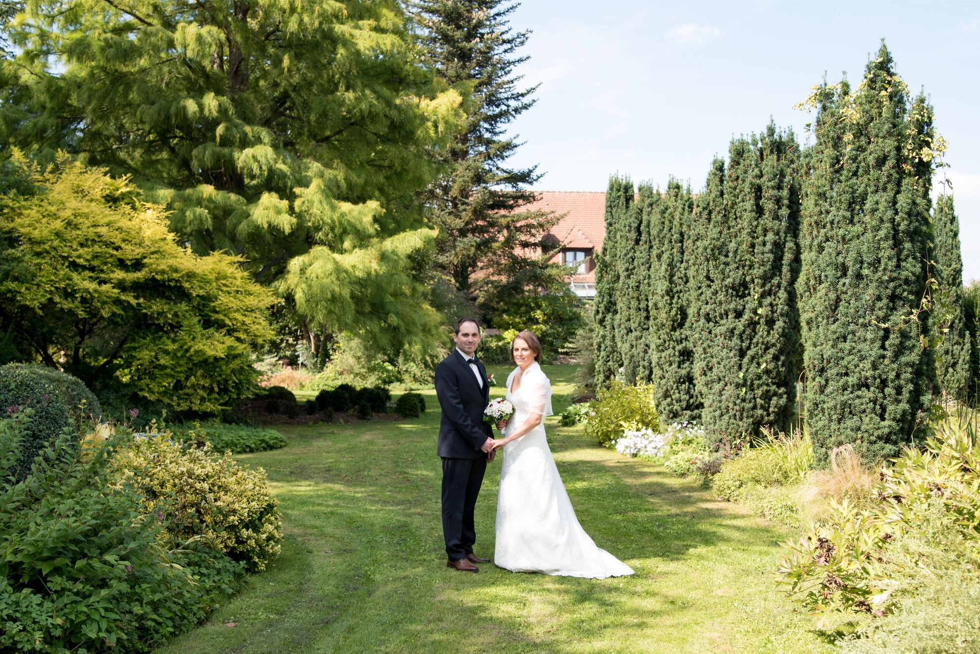 photo de mariés lors de la session couple, dans un jardin, regards vers la photographe professionnelle. séance couple dans le grand est