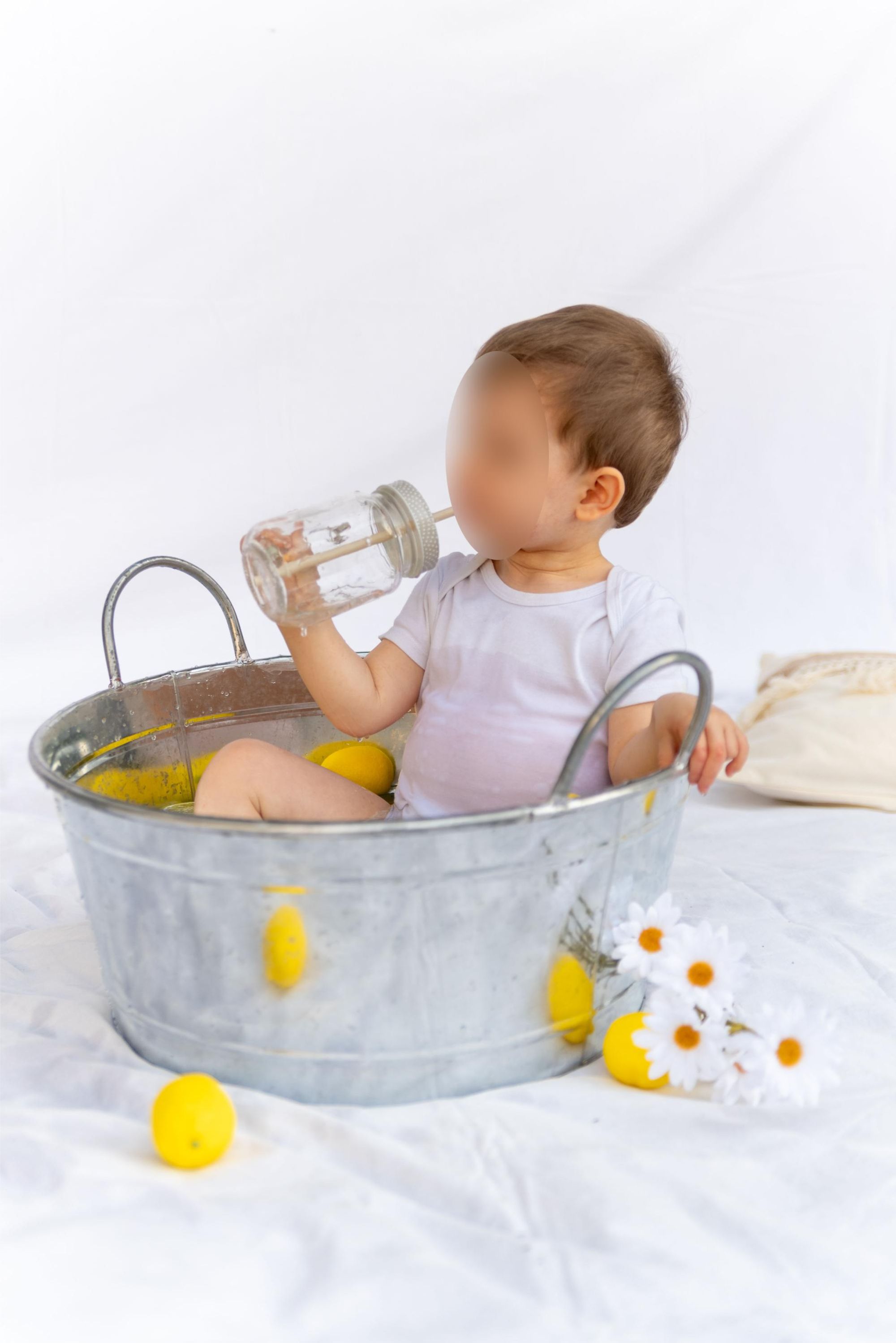 photo d'enfant dans une bassine en extérieur lors d'une mini session thème citron à Besançon 