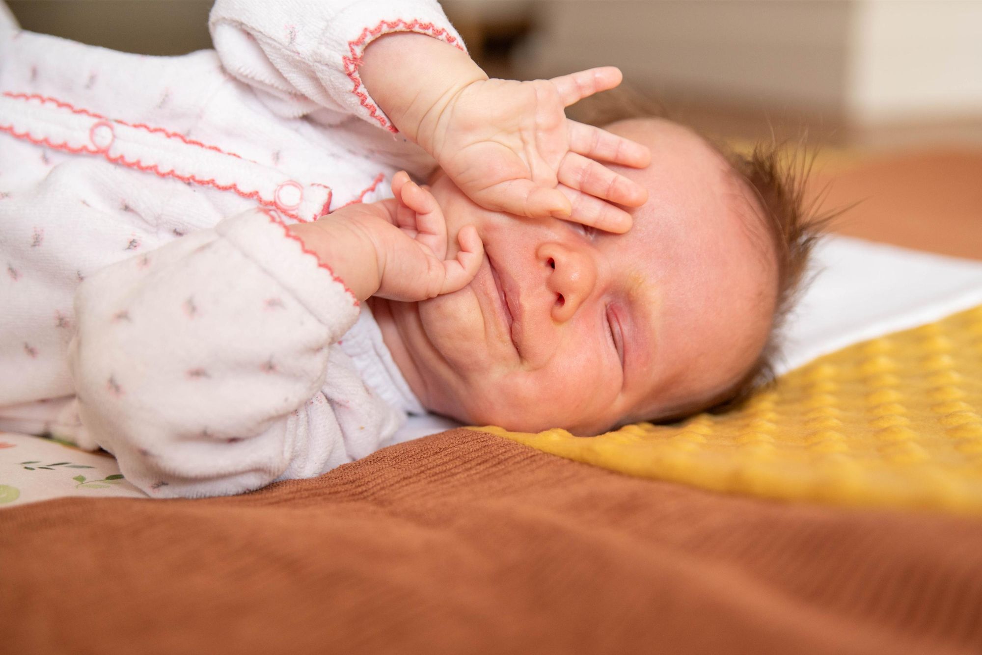 photo d'une petite main de bébé devant ses yeux lors d'une session naissance à Besançon proche du Doubs